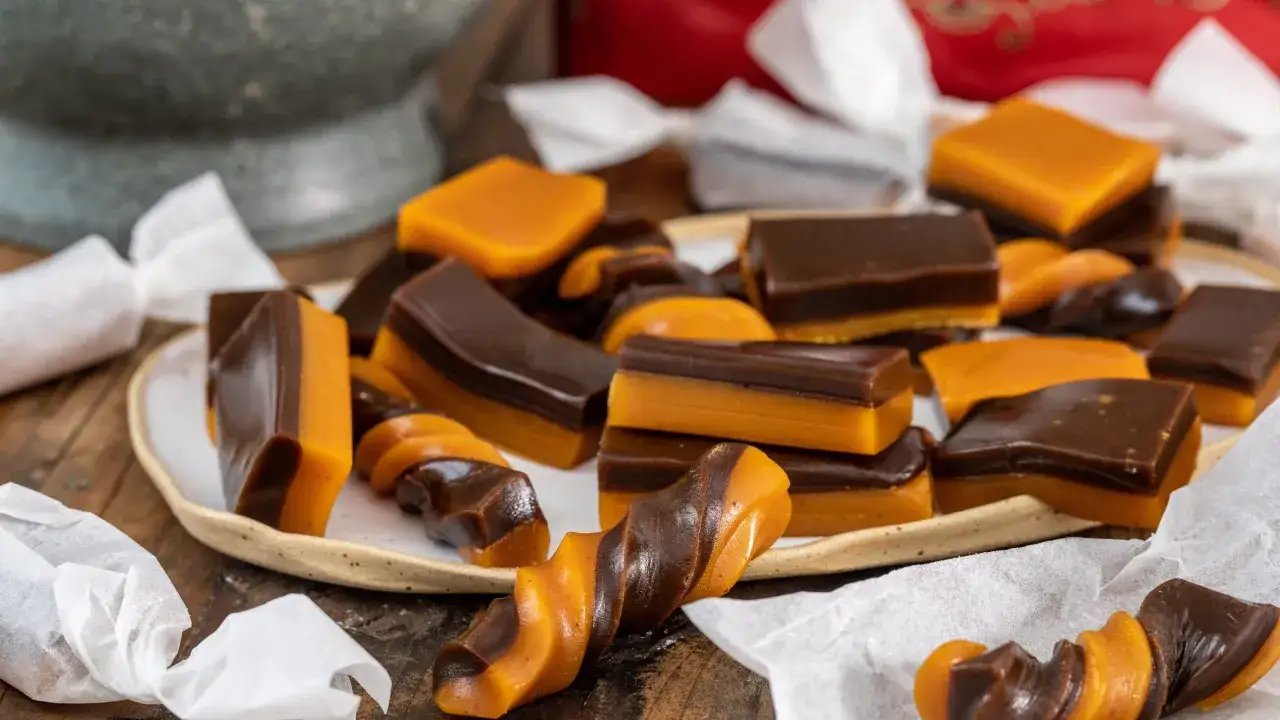 En härlig hög med julgodis med saffran, chokladkola och mjuk kola i olika former, vissa inslagna i papper.