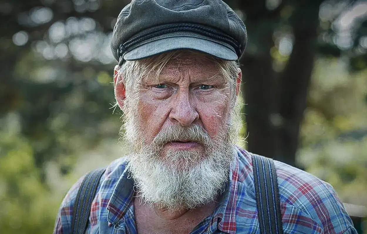 Rolf Lassg&aring;rd i en ny SVT-serie, med gr&aring;tt sk&auml;gg och keps, ser ut som en h&auml;rdad man redo f&ouml;r &auml;ventyr.