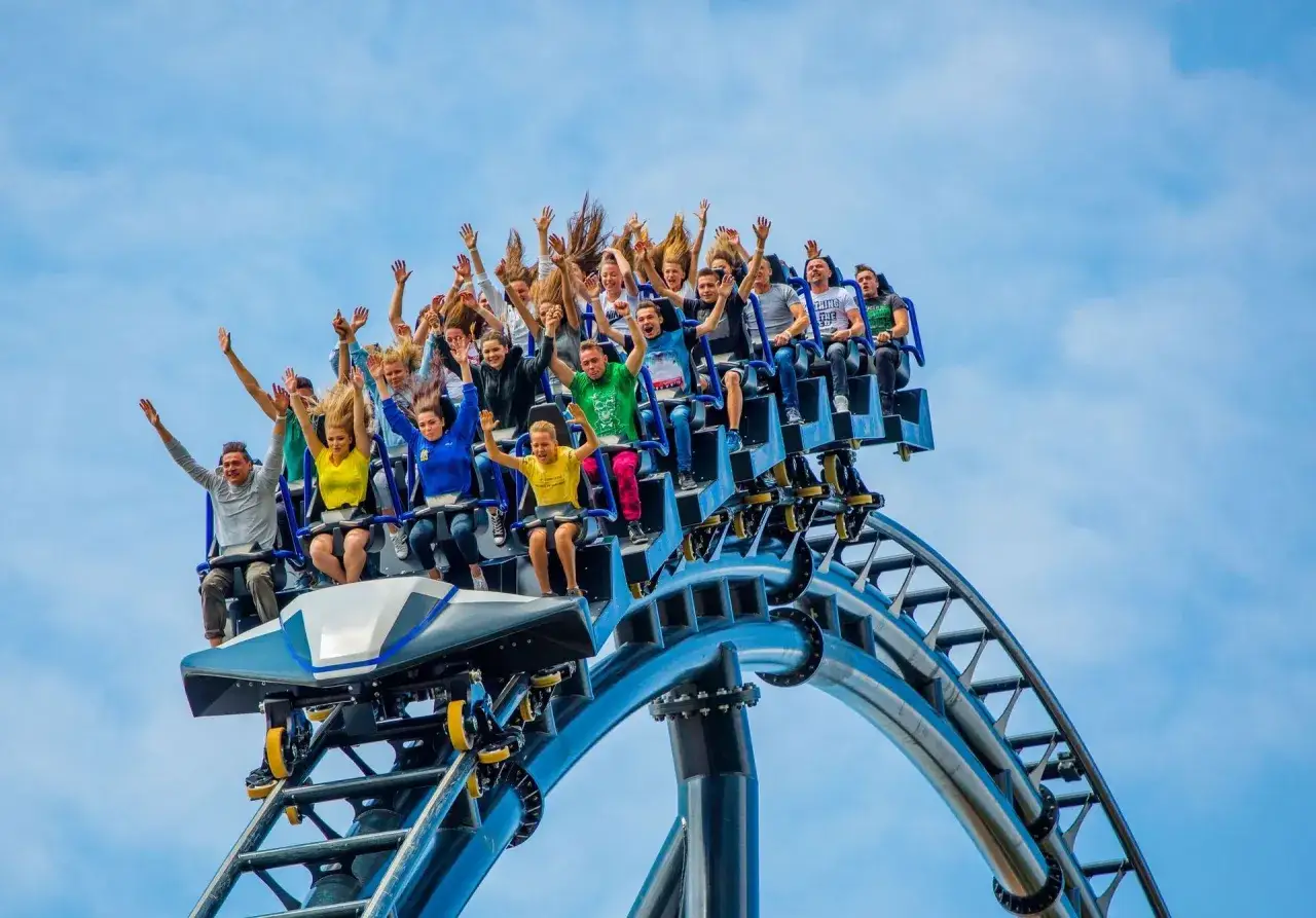Ludzie na kolejce górskiej z rękami w górze, czy to Heide Park czy Energylandia? Niezapomniane emocje gwarantowane!