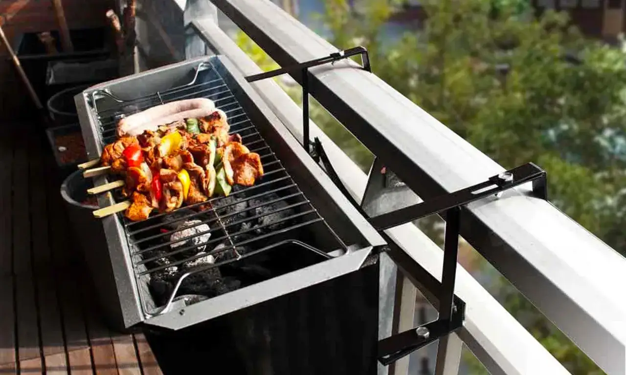 Grill na balkonie z szaszłykami i kiełbasą. Odpowiedź na pytanie: czy można grillować na balkonie?