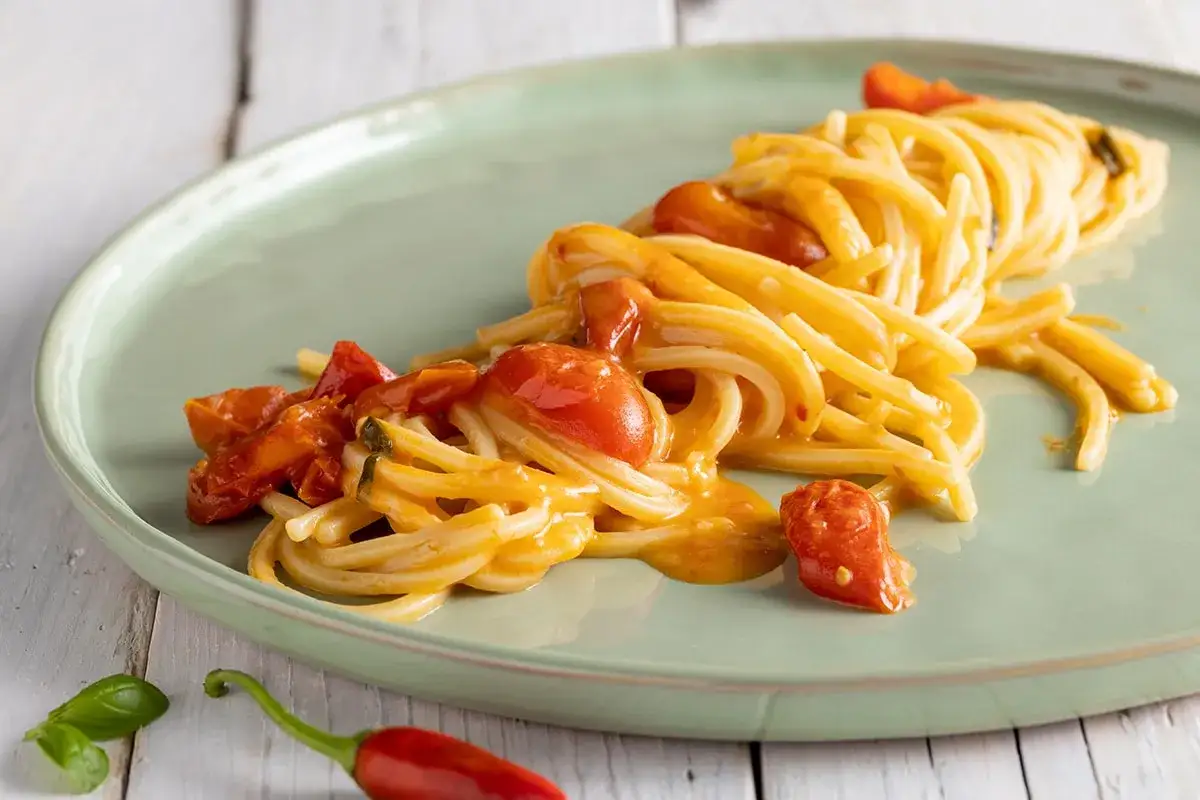 Spaghetti allo scarpariello con pomodorini freschi e peperoncino, un piatto semplice e gustoso.