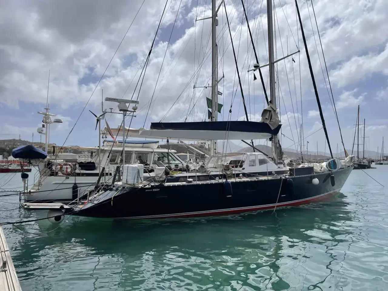 Segelboot im Hafen von Mindelo, Kapverden. Die Sonne spiegelt sich im t&uuml;rkisfarbenen Wasser.