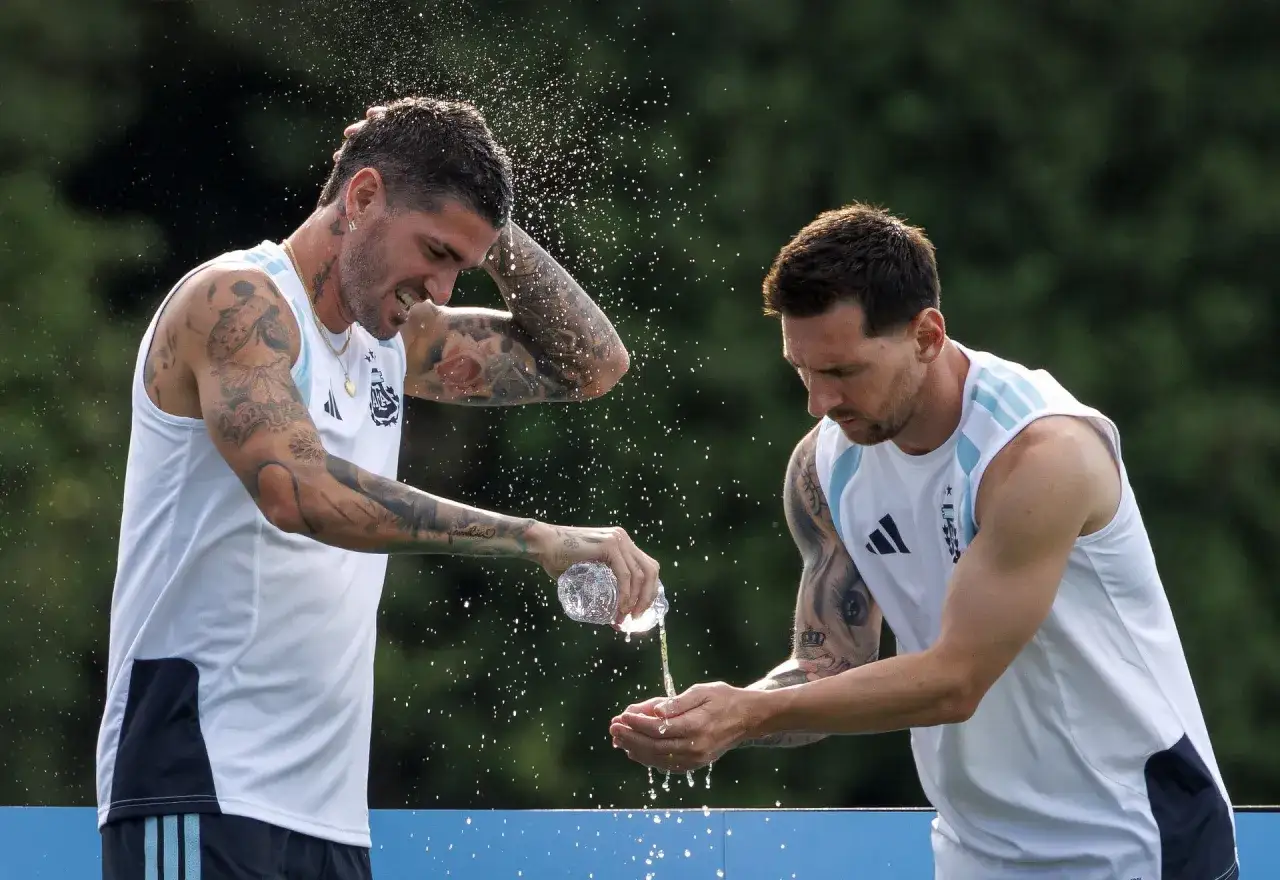 Dwóch najprzystojniejszych piłkarzy, Messi i De Paul, chłodzi się wodą podczas treningu.