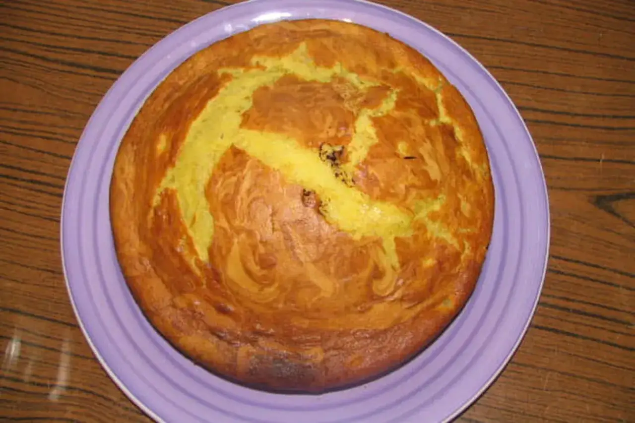 Gâteau moelleux à la banane, doré et appétissant, sur une assiette violette.