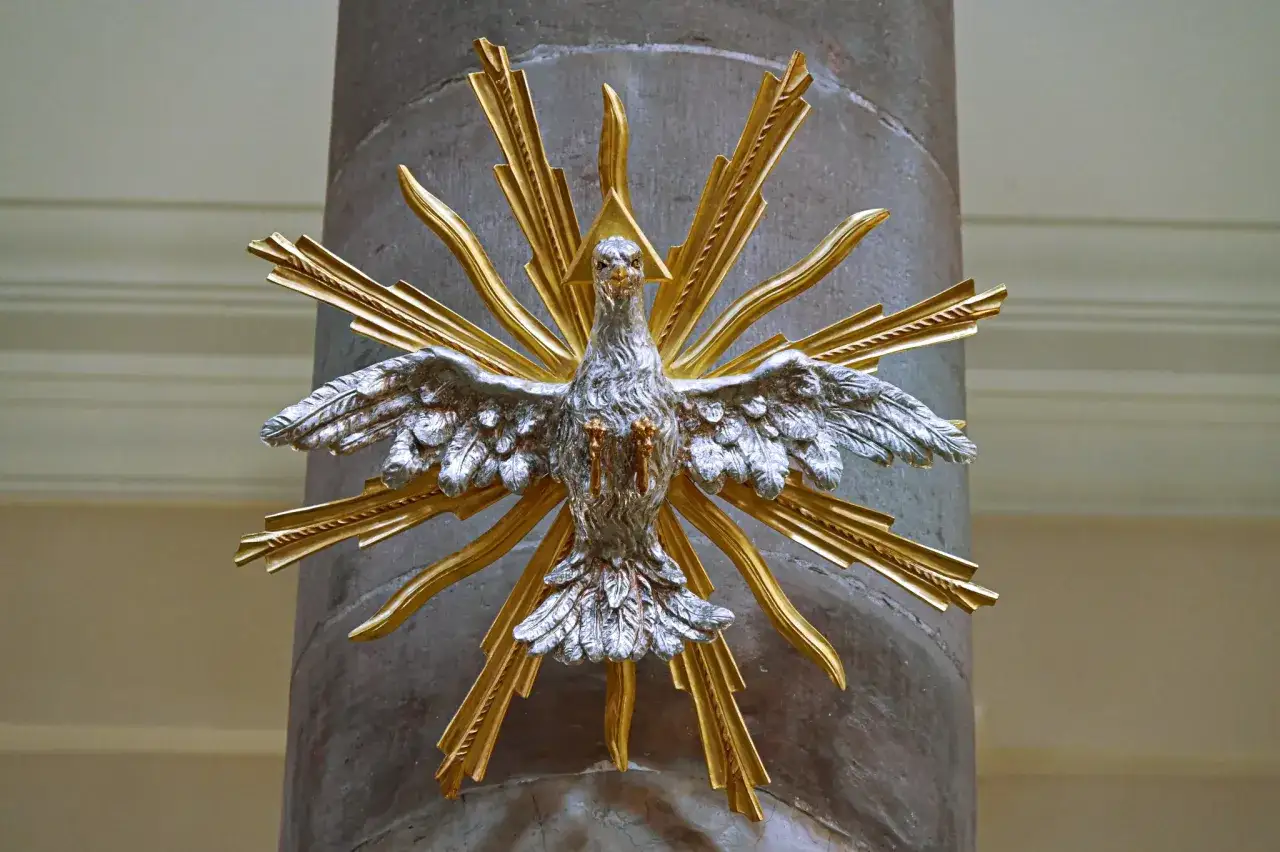 Silberner Taube mit goldenen Strahlen, ein Symbol des Heiligen Geistes, das an einer Säule befestigt ist. Vielleicht ein Blickfang für Pfingsten 2027.