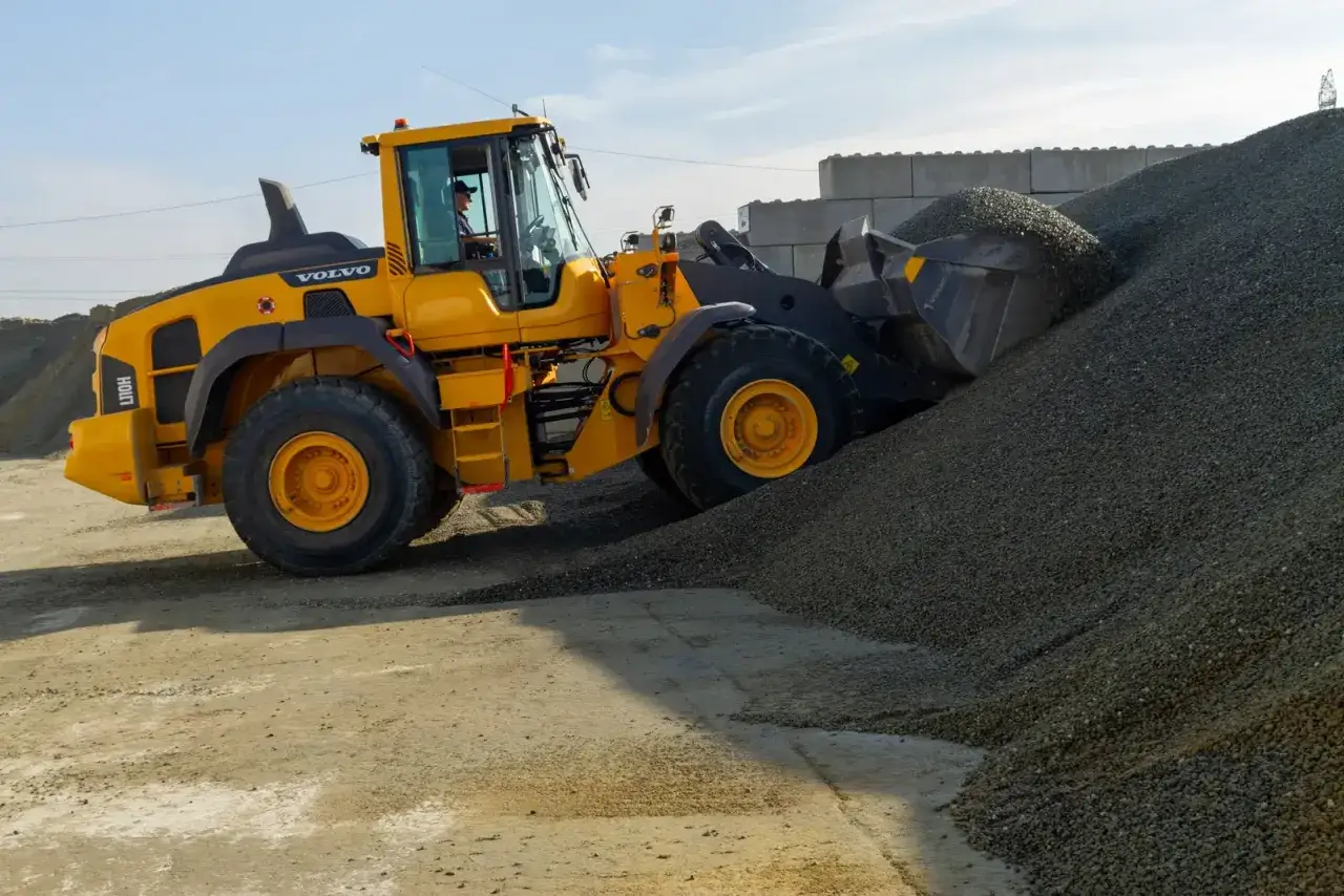 Żółta ładowarka Volvo nabiera żwir, który jest głównym składnikiem betonu.