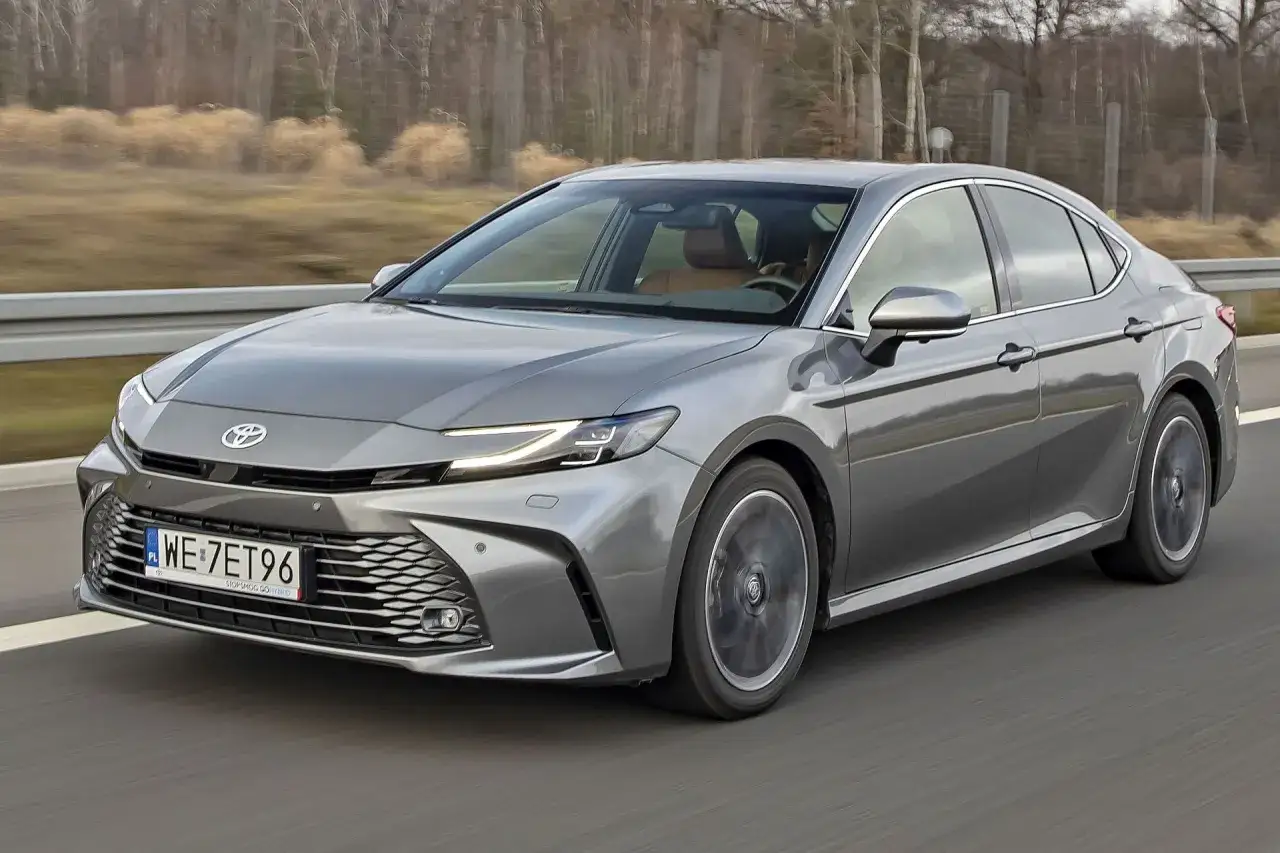 Szary sedan Toyota Camry na drodze. Sprawdź aktualną toyota camry cena i wyposażenie.