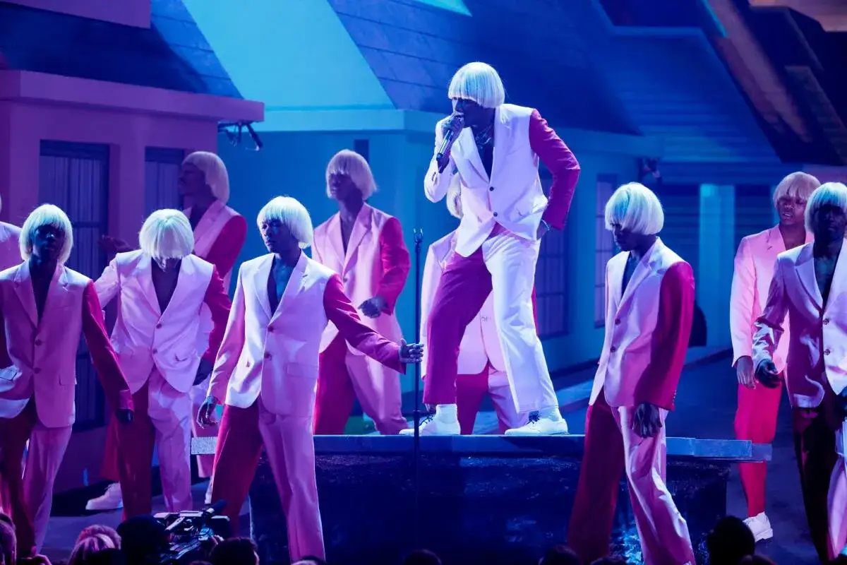 Wykonawcy w r&oacute;żowych garniturach i perukach na scenie, świętujący nagrodę Grammy: najlepsza piosenka - rap.