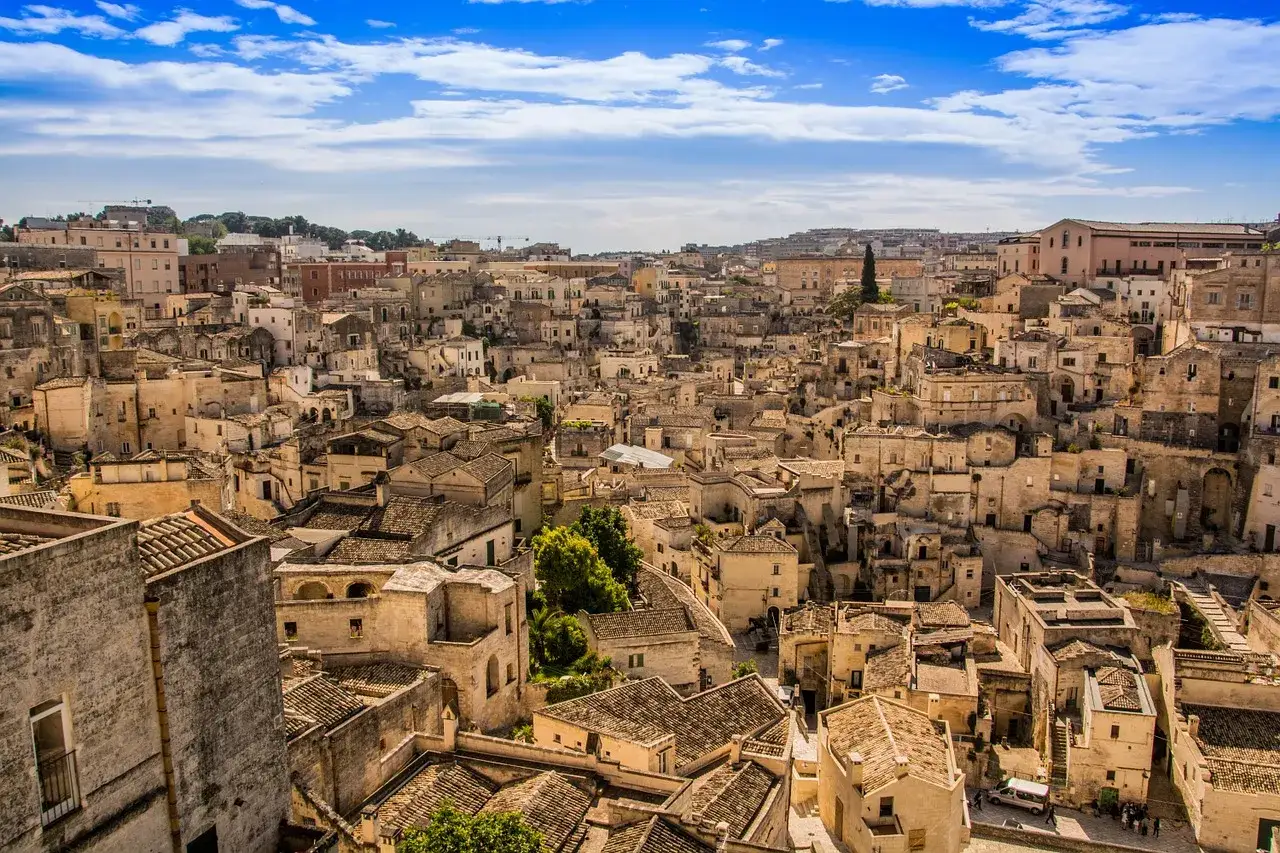 Matera, la citt&agrave; pi&ugrave; antica del mondo, con i suoi Sassi scavati nella roccia e un panorama mozzafiato sotto un cielo azzurro.