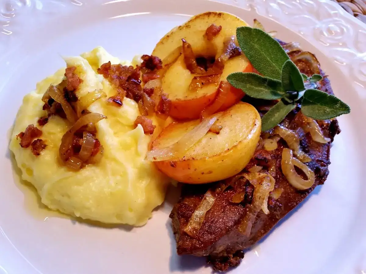 Leber Berliner Art mit Kartoffelpüree, Apfelspalten und gebratenen Zwiebeln, garniert mit Salbei.