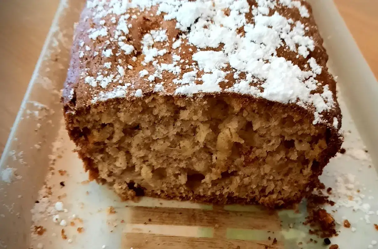 Wilgotna babka bananowa, posypana cukrem pudrem, kusi swoim domowym wyglądem. Idealna na podwieczorek.