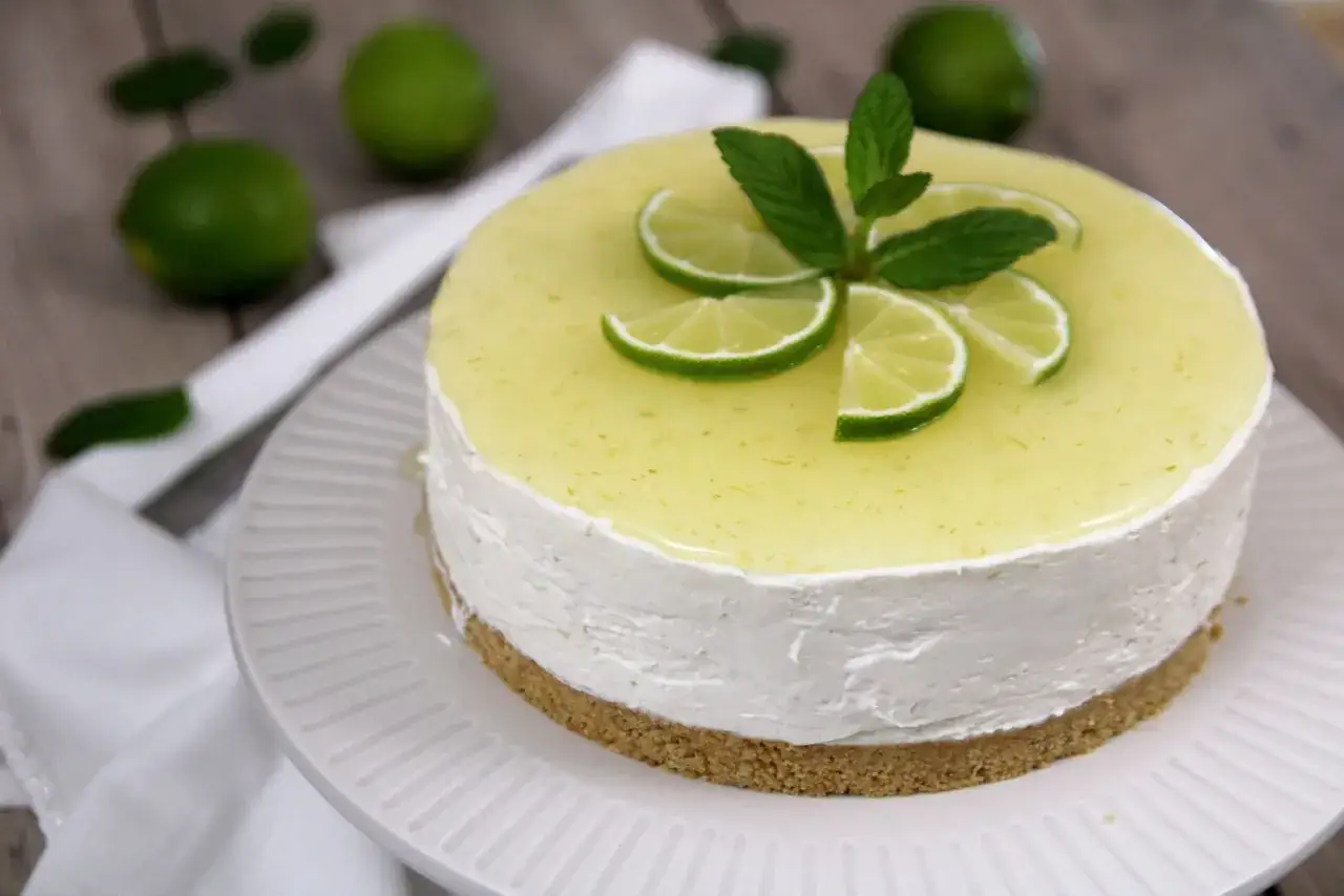 Delizioso cheesecake al mojito, decorato con fettine di lime e menta fresca. Un tripudio di freschezza e gusto.