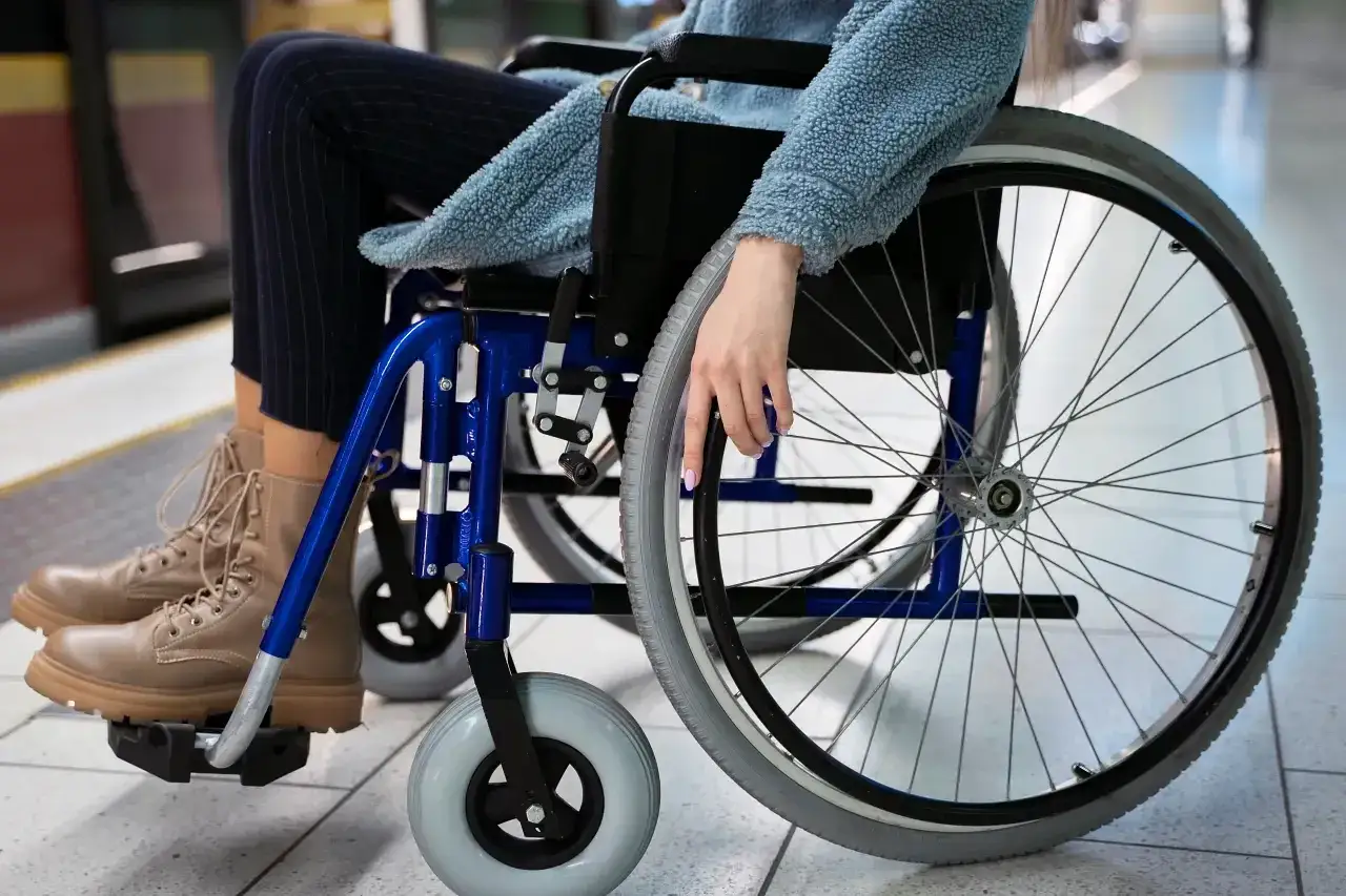 Osoba na wózku inwalidzkim, czekająca na pociąg. Renta inwalidzka zapewnia wsparcie w codziennym życiu.