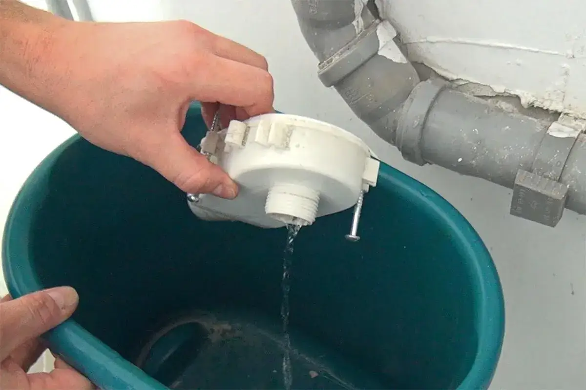 Wasser läuft aus dem ablaufschlauch waschmaschine reinigen Teil in einen Eimer.