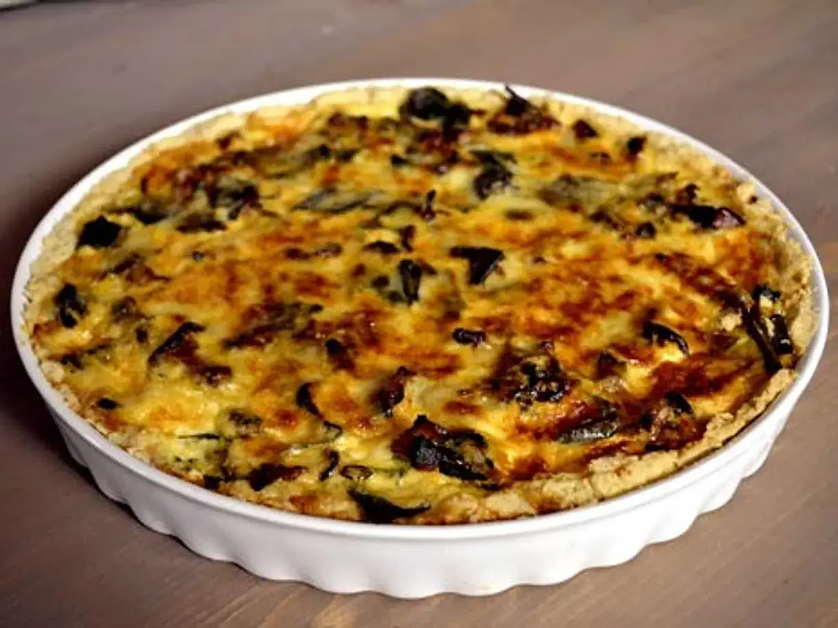 En gyllene kantarellpaj i en vit pajform, perfekt f&ouml;r ett h&ouml;stligt kantarellpaj recept.