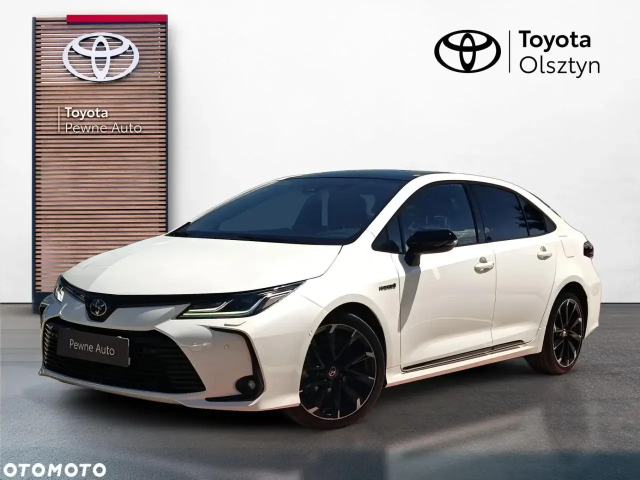 Biała Toyota Corolla z czarnym dachem i felgami. Sprawdź aktualną toyota corolla cena w salonie Toyota Olsztyn.