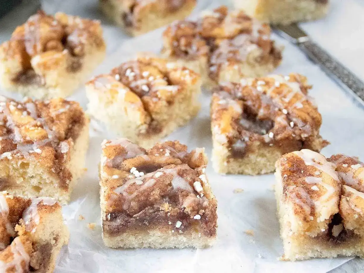 Kanelbullekaka i långpanna, skuren i fyrkantiga bitar med glasyr och pärlsocker. Perfekt för fikat!