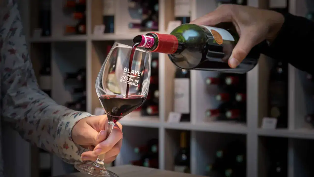 Verre de vin rouge servi d'une bouteille, marqué