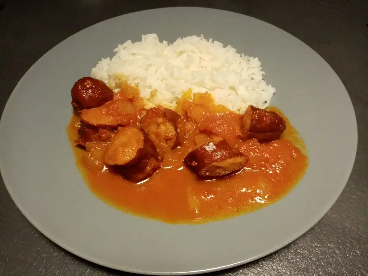 Rougail saucisse Cookeo, un plat savoureux avec riz blanc et saucisses coup&eacute;es en rondelles dans une sauce tomate &eacute;pic&eacute;e.