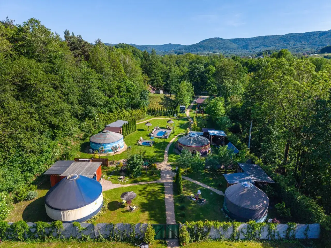 Malowniczy aloha glamp z jurtami, basenem i jacuzzi, otoczony zielenią i wzgórzami. Idealne miejsce na relaks.