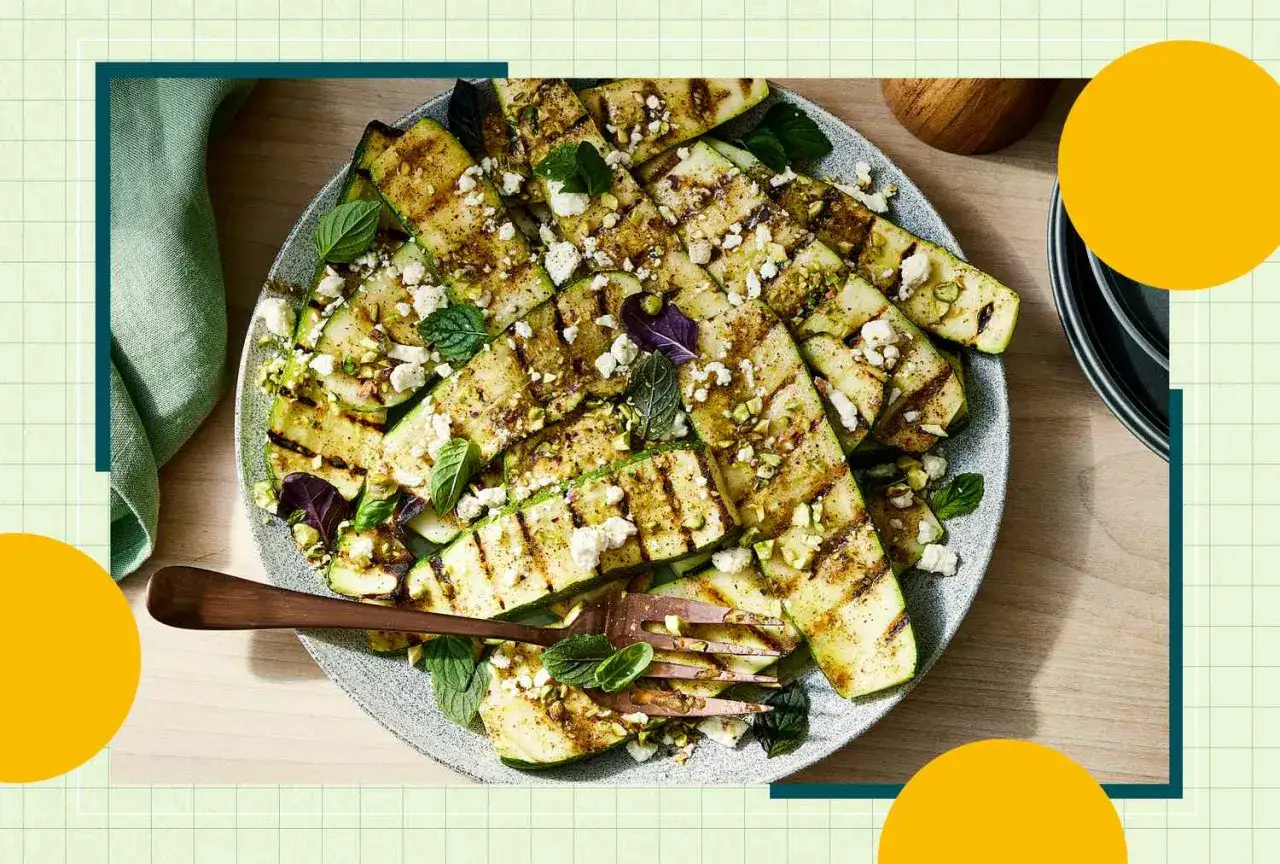 Gegrillte Zucchinischeiben mit Feta und Pistazien, garniert mit Minze. Ein köstliches und zucchini gesund Gericht.