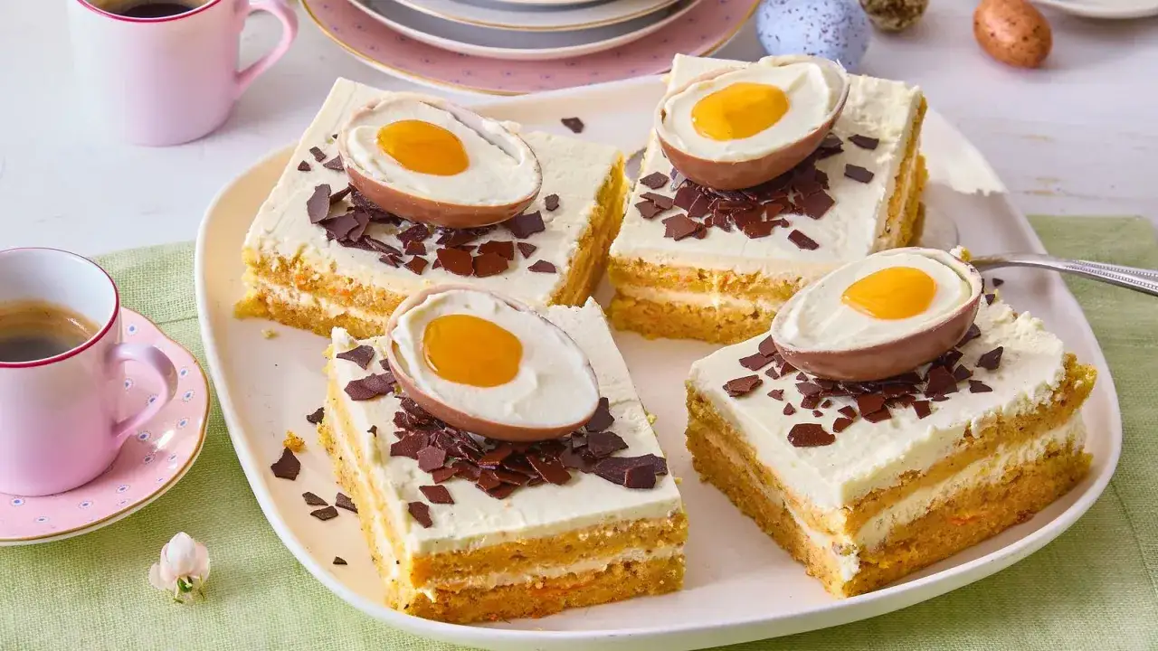 Vier St&uuml;cke typische Osterkuchen mit Schokoladeneiern und Schokostreuseln auf einem Teller, daneben Kaffeetassen.