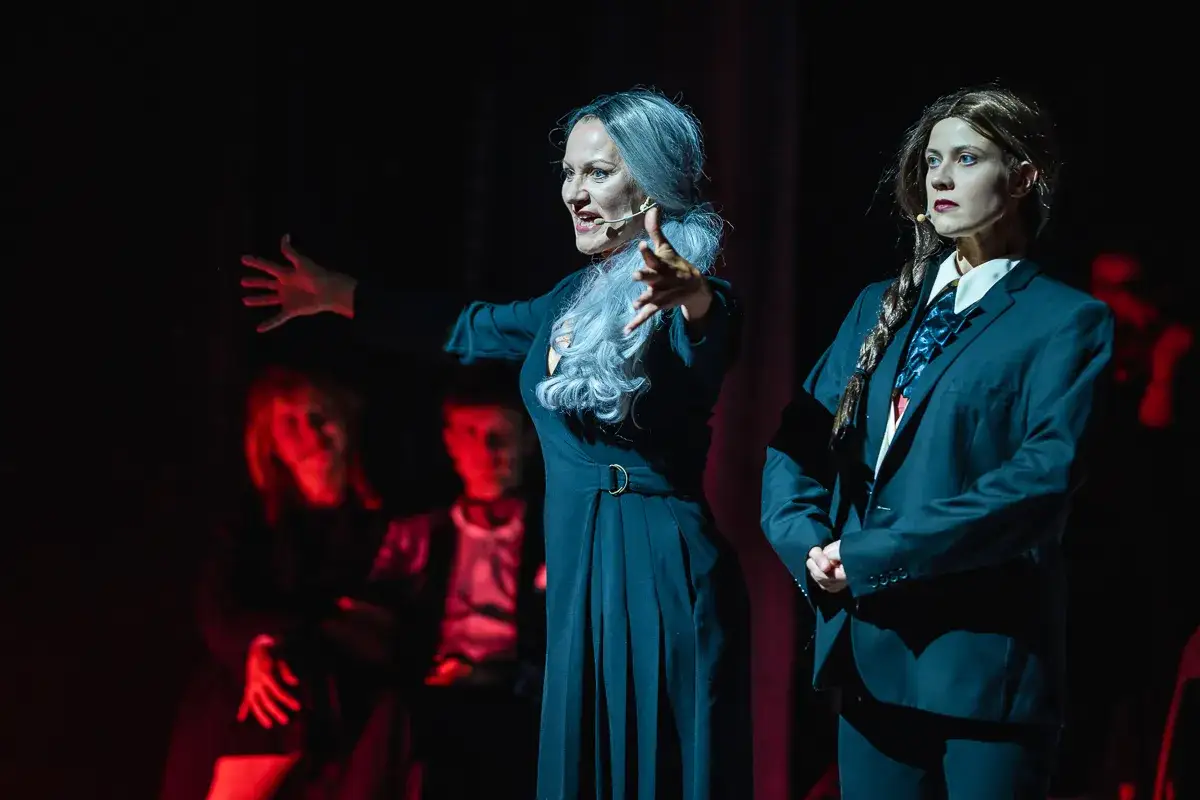 Aktorki na scenie, jedna w czarnej sukni, druga w garniturze. Spektakl godny najlepszych teatrów w Polsce.