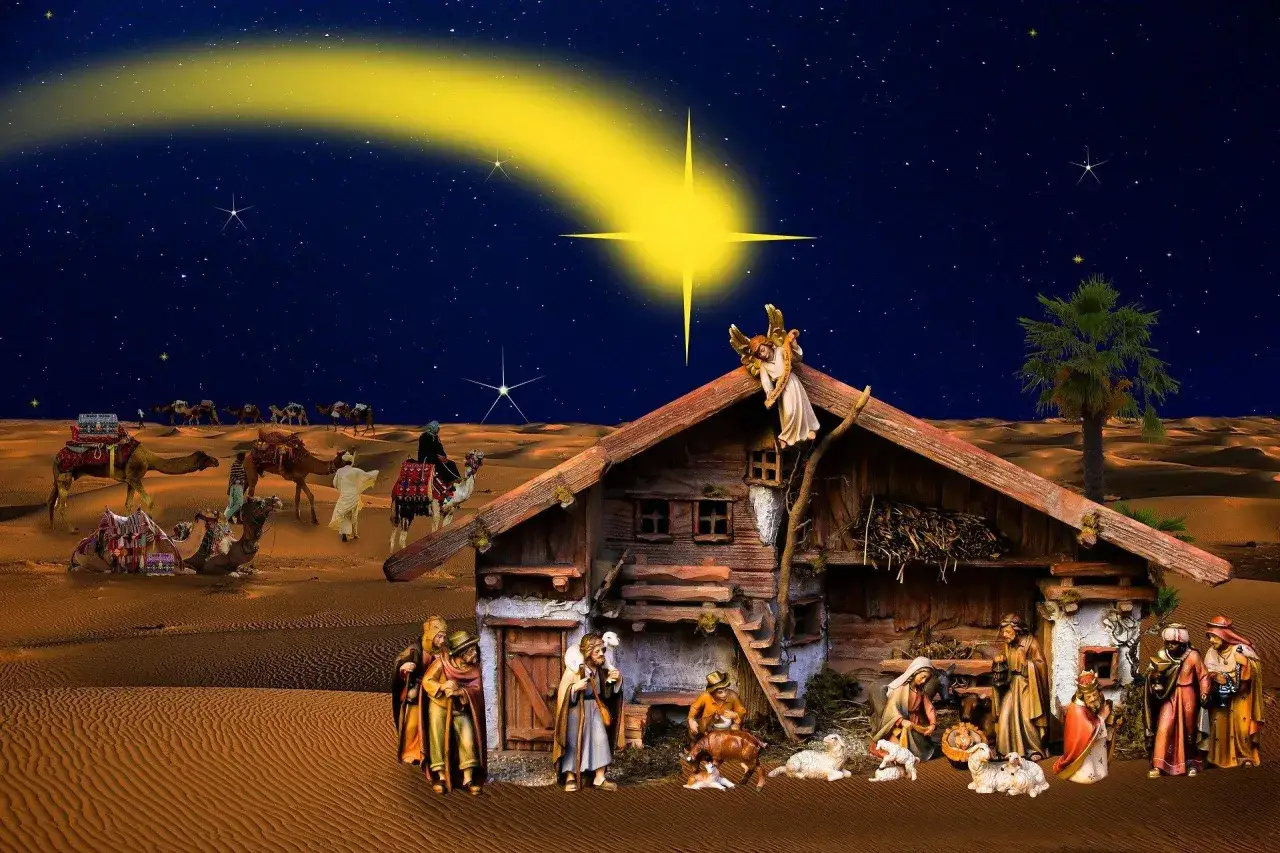 Krippenszene mit Maria, Josef und dem Jesuskind in einem Stall, umgeben von Hirten und Tieren. &Uuml;ber ihnen leuchtet der helle Weihnachtsstern, der die Bedeutung der Geburt Jesu symbolisiert. Kamelkarawanen ziehen durch die W&uuml;ste.