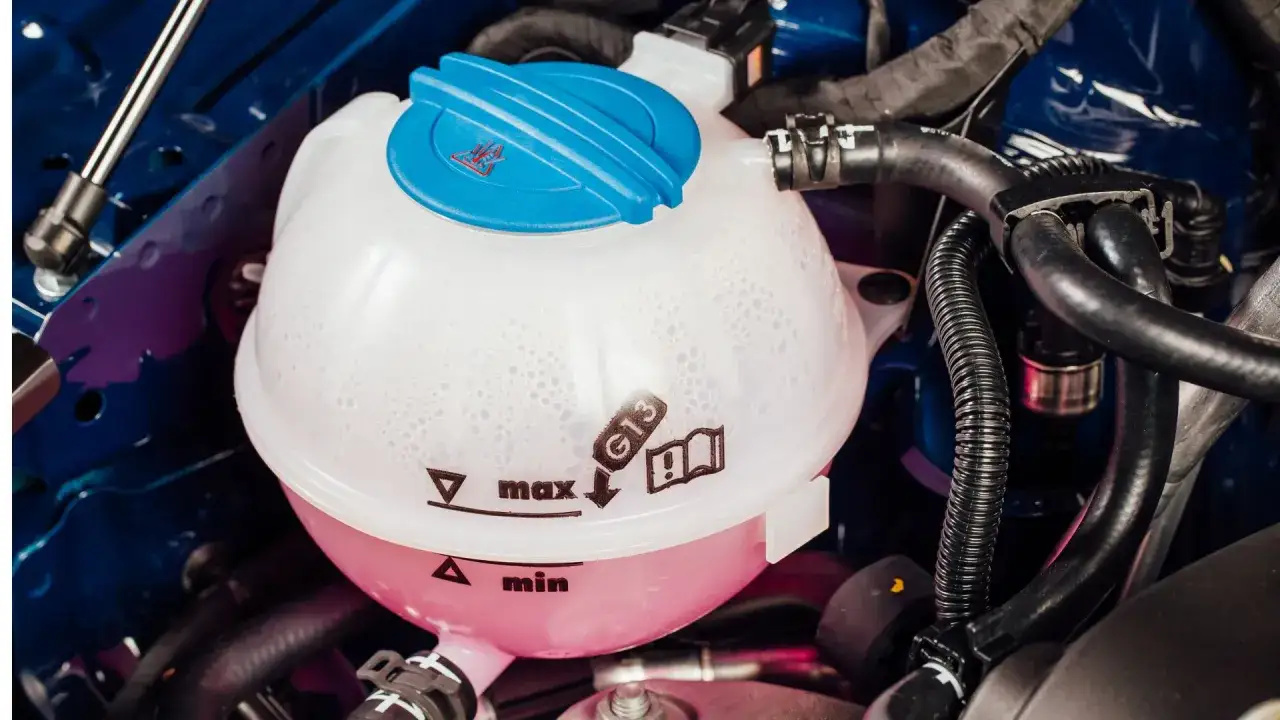 Le réservoir de liquide de refroidissement rose et blanc, avec les indications 