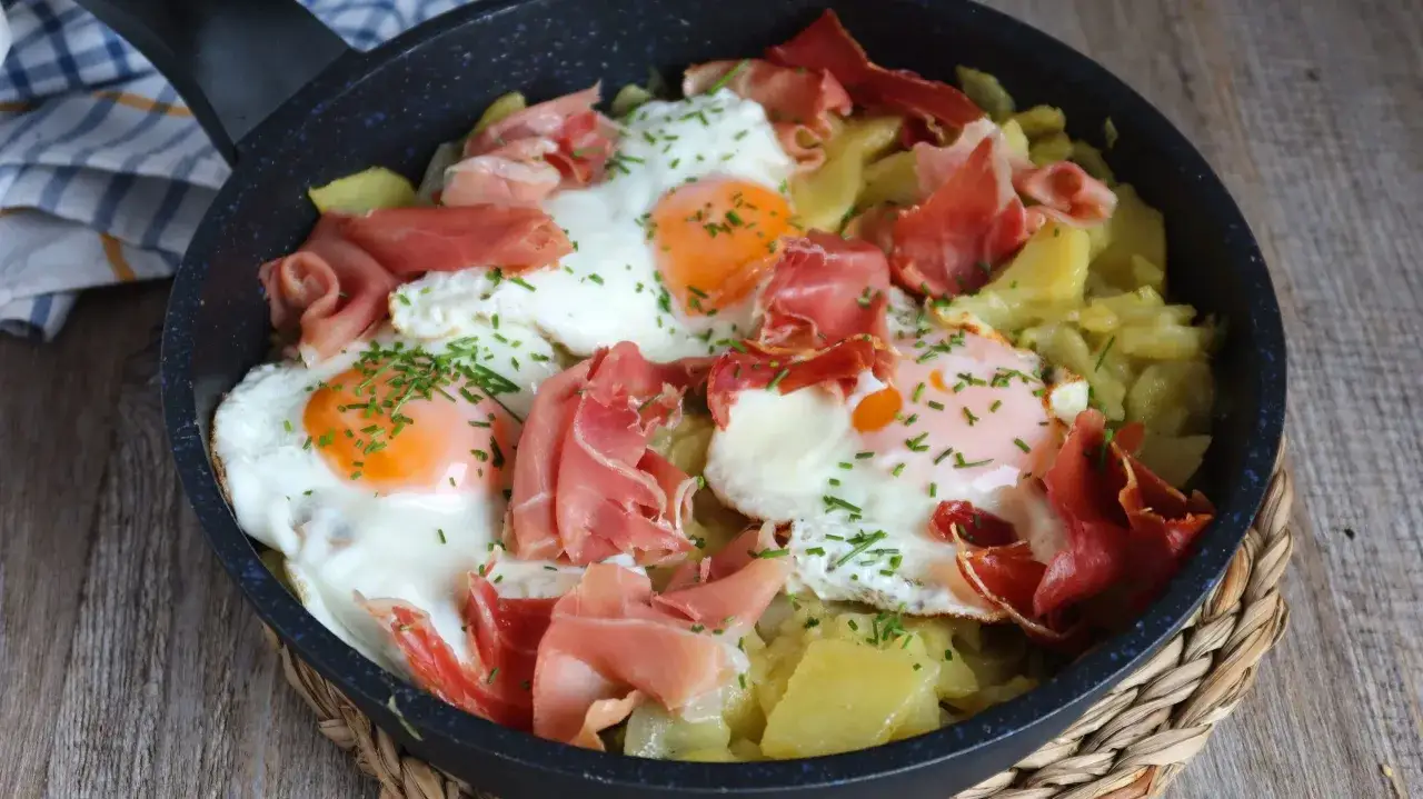 Huevos rotos con patatas y jamón serrano, un plato delicioso y reconfortante.
