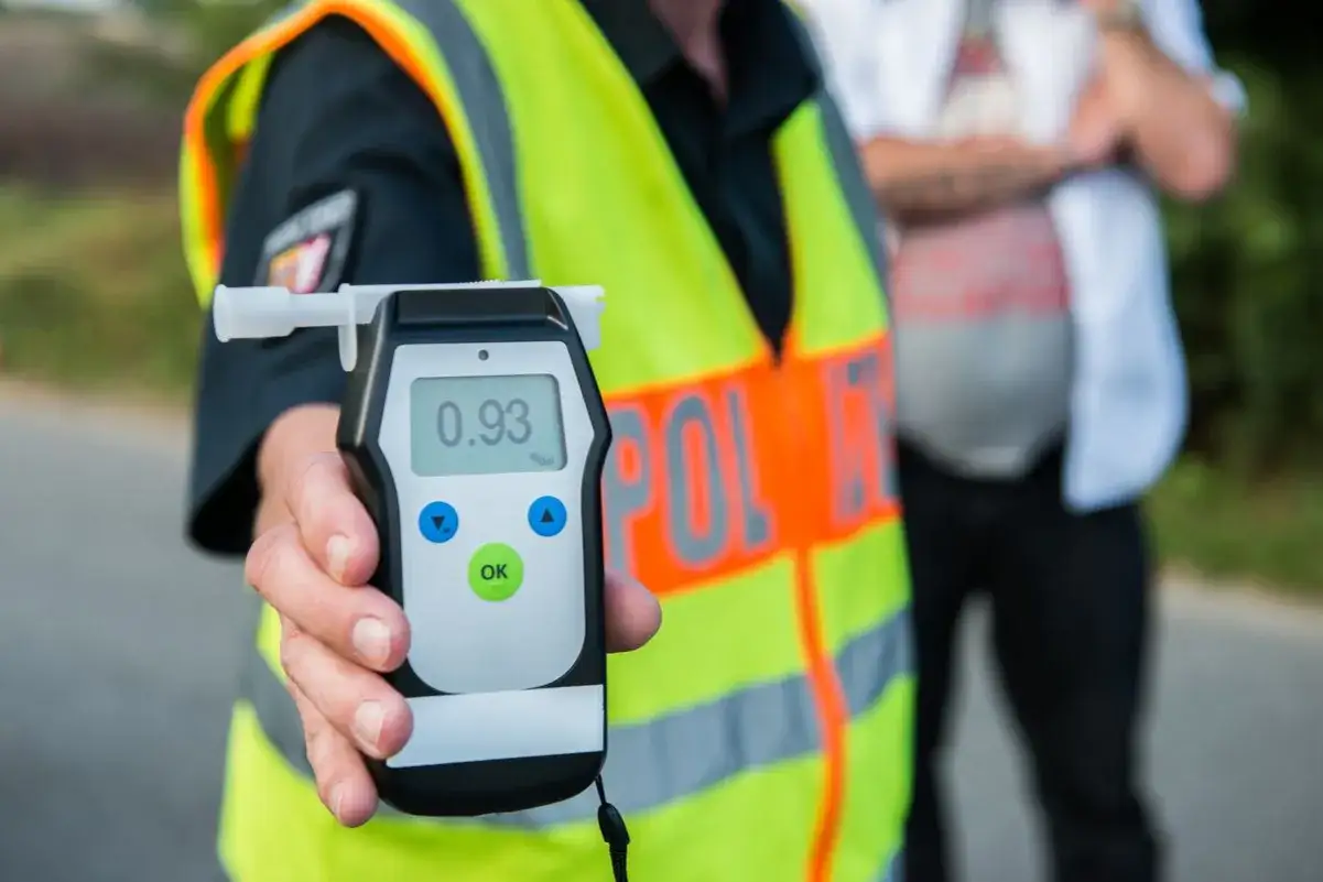 Policjant pokazuje alkomat z wynikiem 0.93 promila. To ważny pomiar poziomu alkoholu we krwi podczas kontroli drogowej.