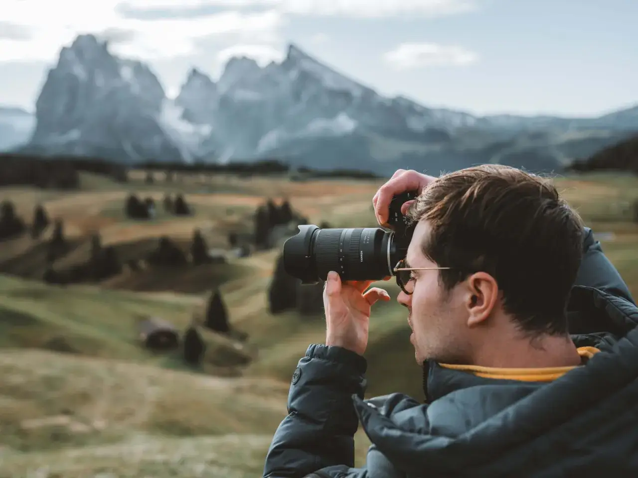 Mężczyzna z aparatem fotograficznym w górach, tworzy swój foto blog.