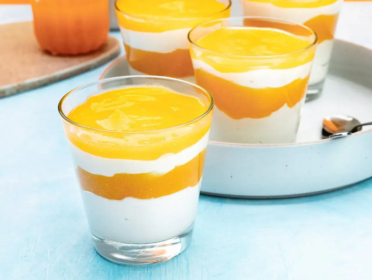 Schichtdessert mit cremigem griechischem Joghurt und fruchtiger Mango- oder Maracuja-Soße. Ein erfrischendes Solero Dessert.