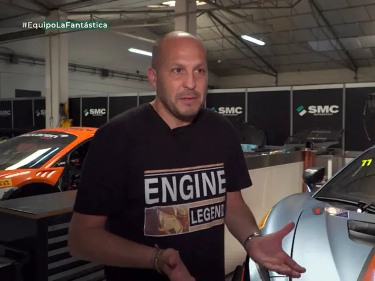 Fernando Navarrete, piloto, habla en un taller con autos de carrera.