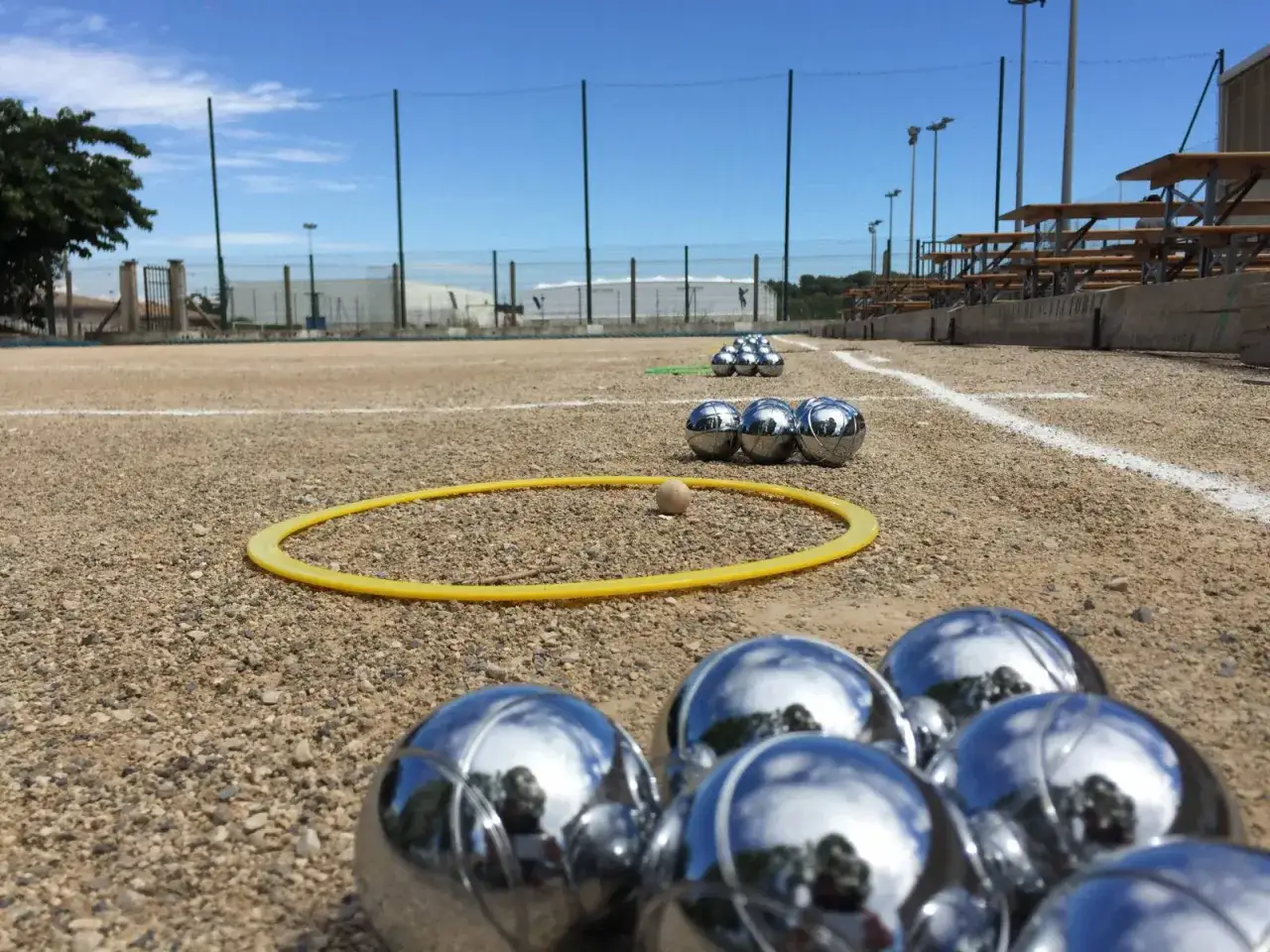 Boules : des boules m&eacute;talliques et une petite boule en bois sur un terrain de p&eacute;tanque, pr&ecirc;ts pour une partie.