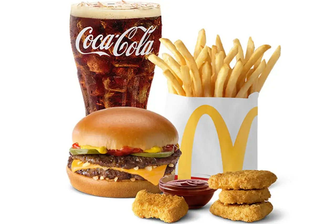 Zestaw McDonald's: podwójny cheeseburger, frytki, cola i chrupiące McNuggets z sosem.