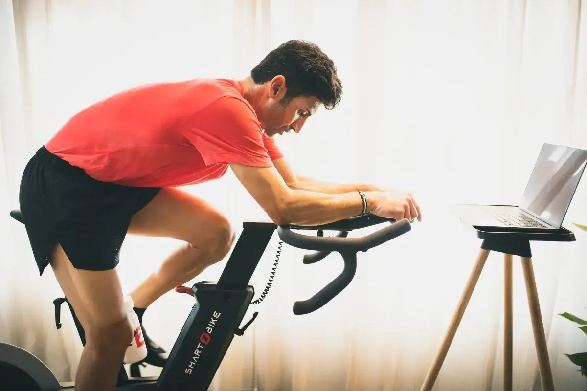 Mężczyzna ćwiczy na rowerze stacjonarnym, kt&oacute;ry może być dobrym wyborem, jeśli zastanawiasz się, jaki rower stacjonarny do rehabilitacji kolana.
