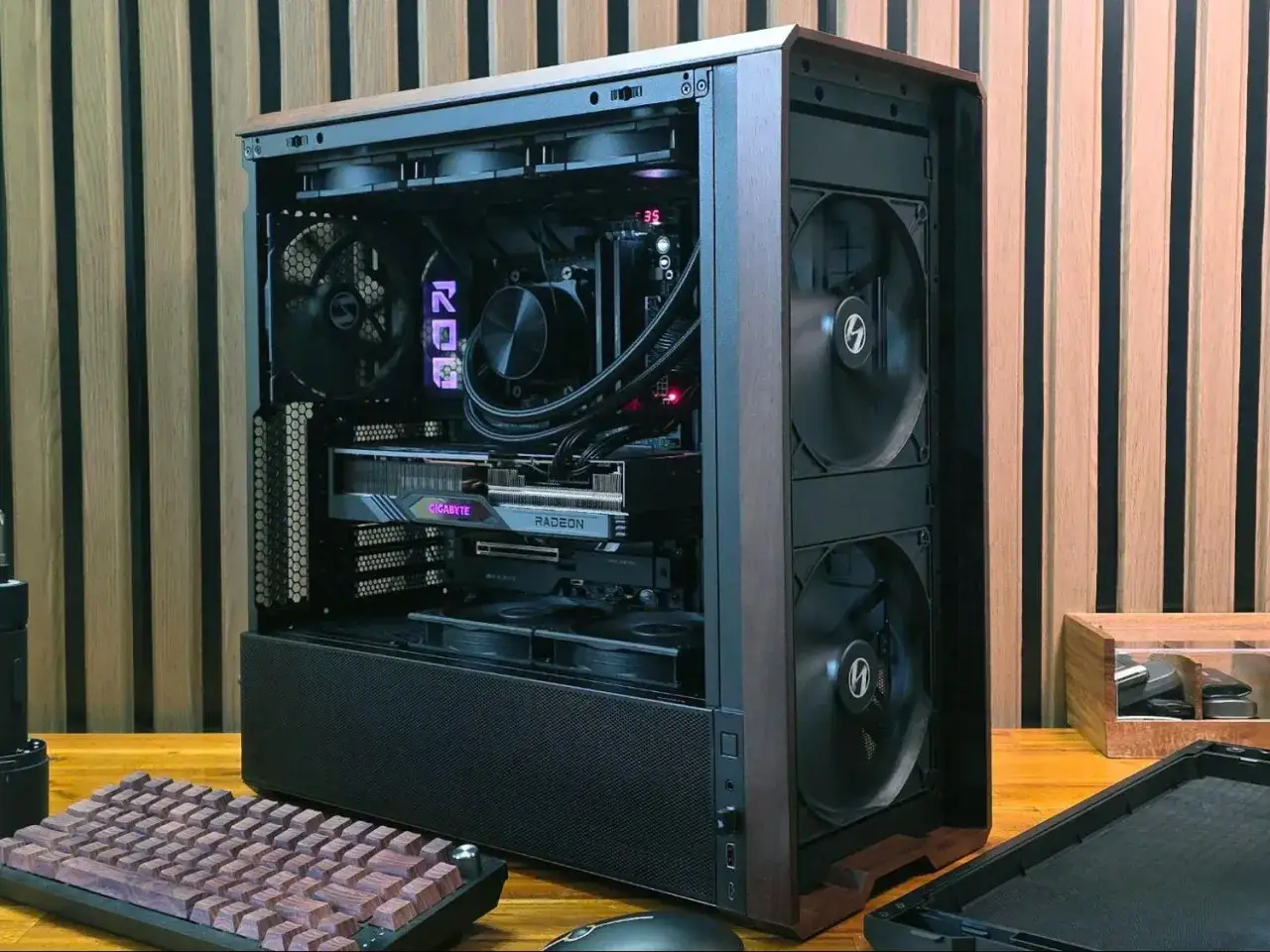 Nowoczesna budowa komputera z kartą Radeon i chłodzeniem wodnym. Drewniane akcenty obudowy i klawiatury nadają mu unikalny styl.