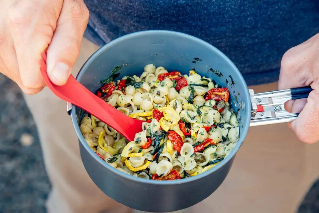 A pot of pasta with sun-dried tomatoes and zucchini, perfect for dehydrating food for backpacking.