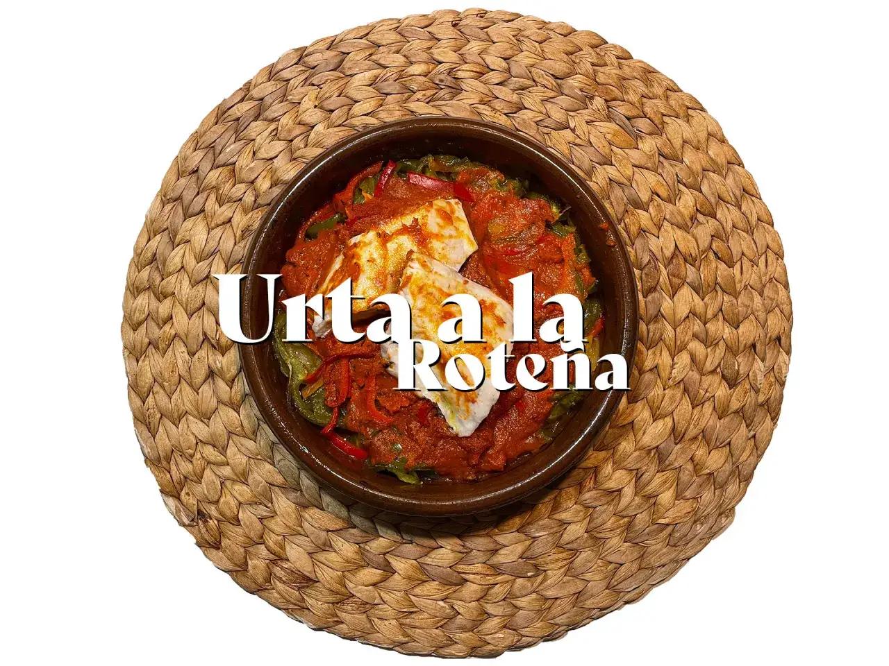 Un plato de urta a la rote&ntilde;a, con trozos de pescado blanco en una salsa roja con pimientos verdes y rojos, servido en cazuela de barro sobre una esterilla.