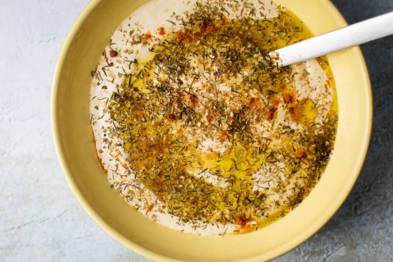 Cremiger Hummus, frisch zubereitet, mit Oliven&ouml;l, Kr&auml;utern und Paprikapulver garniert. Perfekt zum Hummus selber machen!