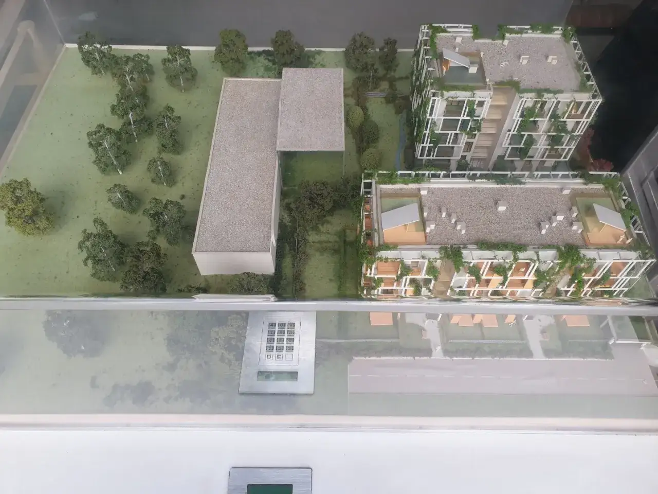 Model osiedla z zielenią i nowoczesnymi budynkami. Zastanawiasz się, ile zarabia architekt tworzący takie projekty?