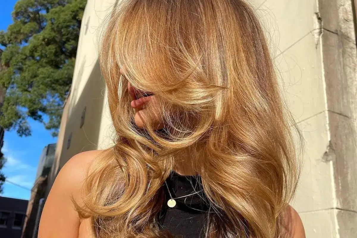 Karmelowy blond w objęciach słońca, zmysłowo opada na ramiona.
