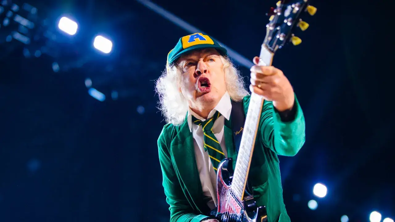Angus Young z AC/DC, jeden z legendarnych zespołów rockowych zagranicznych alfabetycznie, w akcji na scenie.