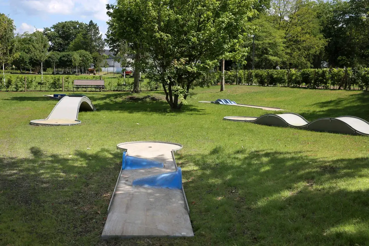 Minigolf Wiehl: Eine sonnige Anlage mit mehreren Bahnen, darunter eine mit Tunnel und eine wellige Strecke, l&auml;dt zum Spiel ein.