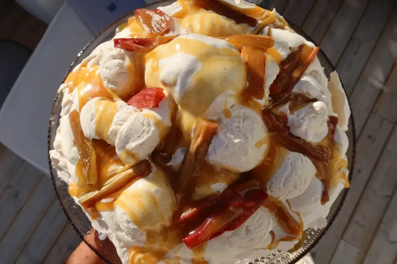 En stor pavlova rabarber med vaniljglass och kolasås. En härlig sommardessert!