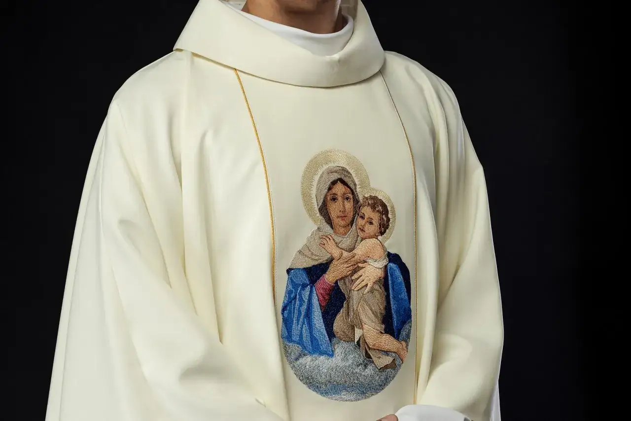 Szata kapłańska z haftem Matki Boskiej z Dzieciątkiem. Może symbolizować przyczyny zmian w tekstach modlitw w nowym mszale rzymskim.