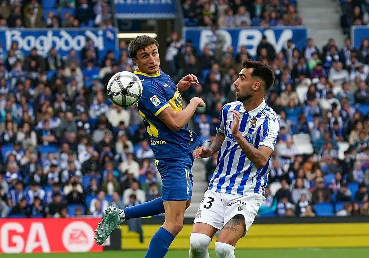 Jugadores del Alav&eacute;s y Real Sociedad luchan por el bal&oacute;n en el aire. La tensi&oacute;n del partido es palpable.