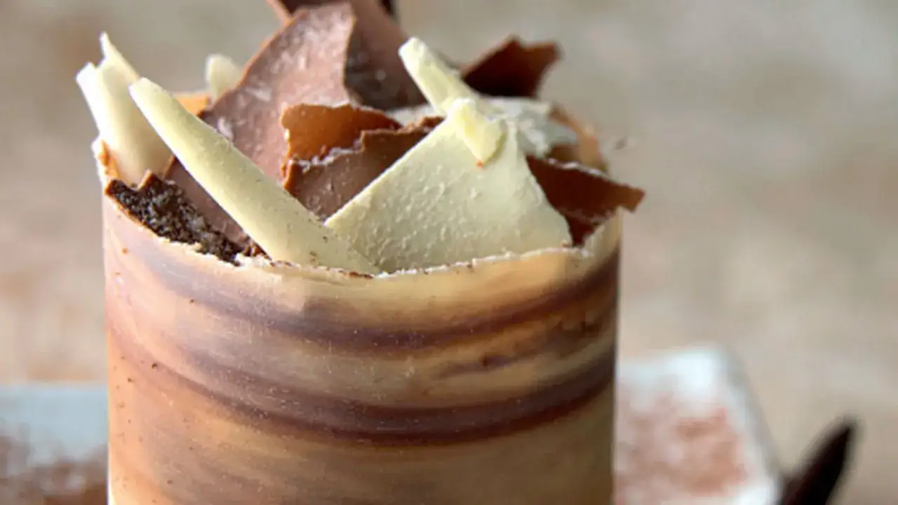 Delicioso mousse de caf&eacute; envuelto en chocolate marmoleado, coronado con virutas de chocolate blanco y oscuro.
