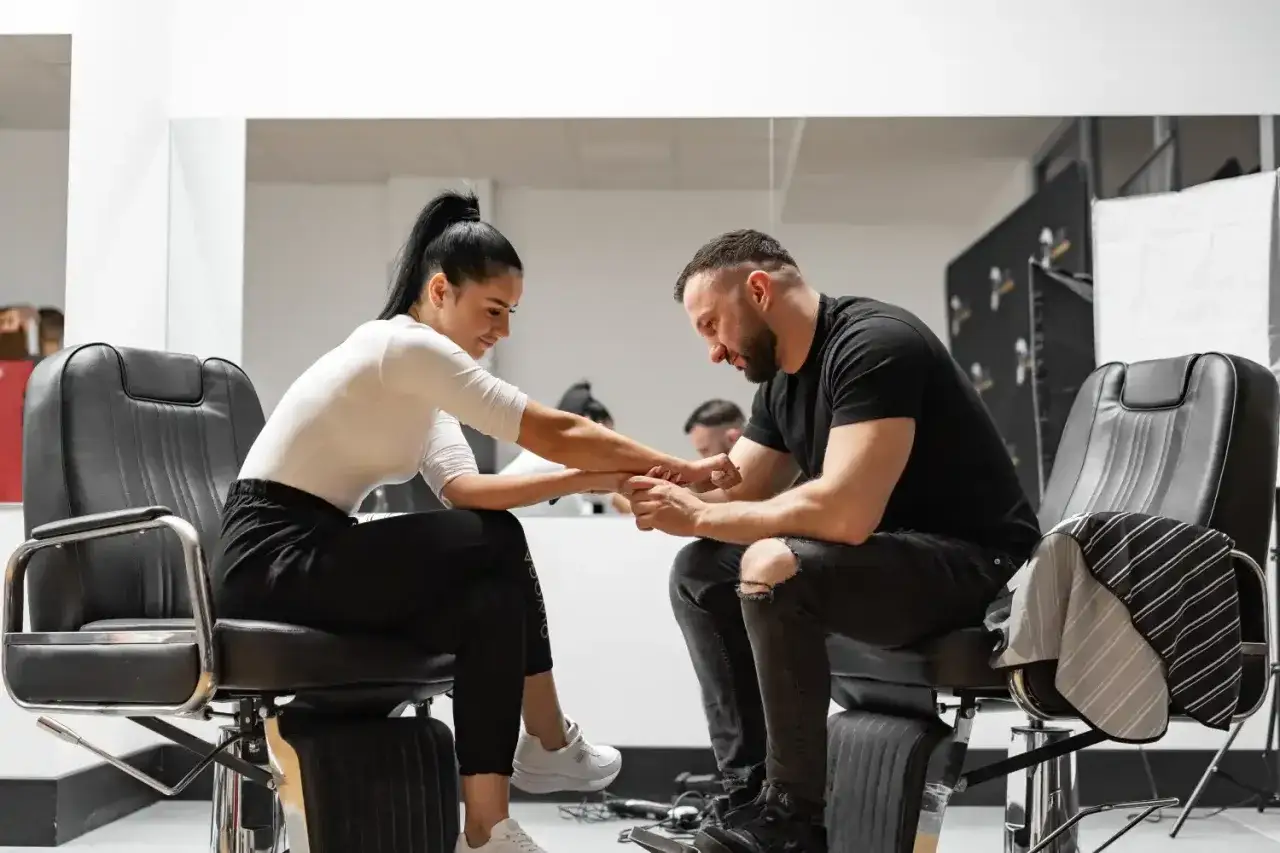 Barber w salonie, skupiony na pracy. Zastanawiasz się, ile zarabia barber? To zależy od wielu czynników, ale umiejętności i doświadczenie są kluczowe.